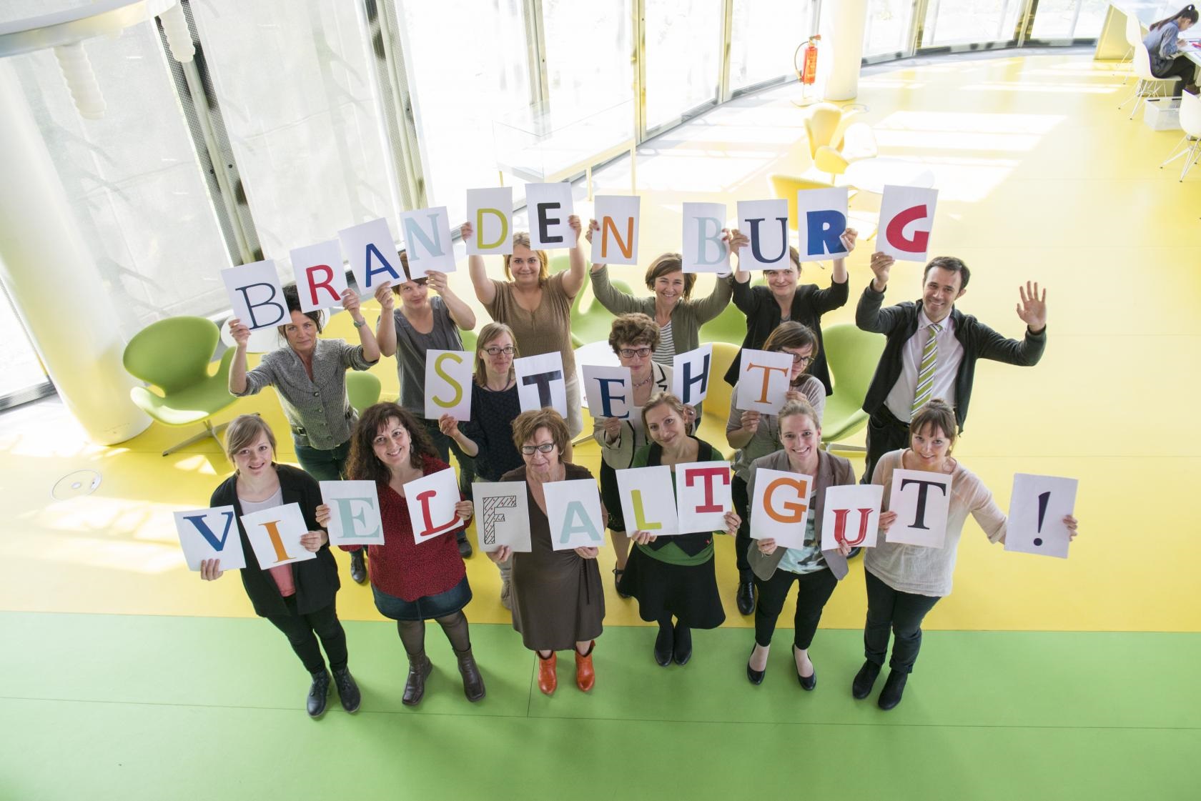 Foto zum Diversity Tag 2015 Beteiligte im Landesnetzwerk IQ (Integration durch Qualifzierung) halten den Textzug Brandenburg tut Vielfalt gut hoch.